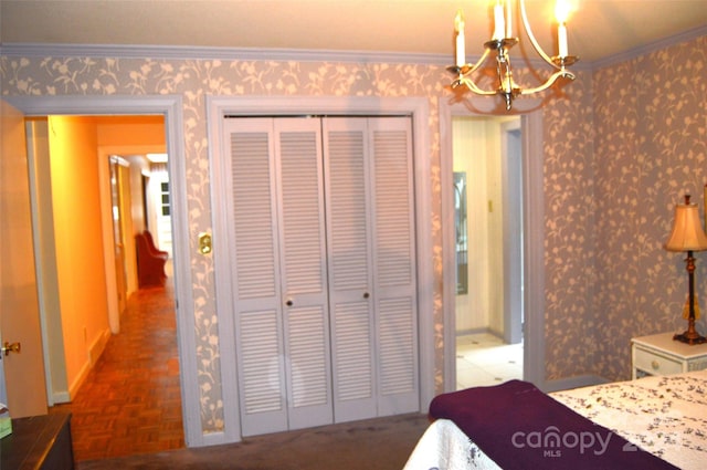 bedroom with parquet flooring, crown molding, an inviting chandelier, and a closet