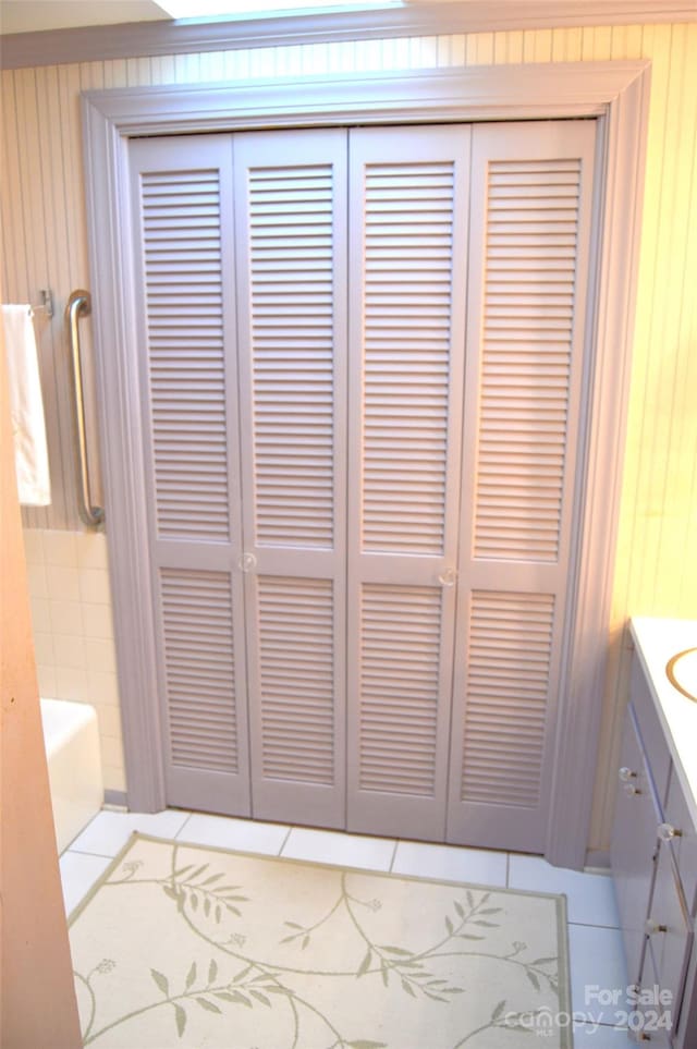 details featuring tile patterned flooring, a tub to relax in, and vanity