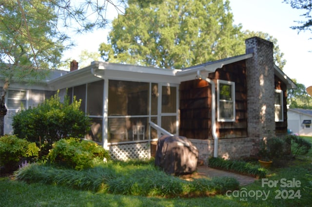 back of property with a sunroom