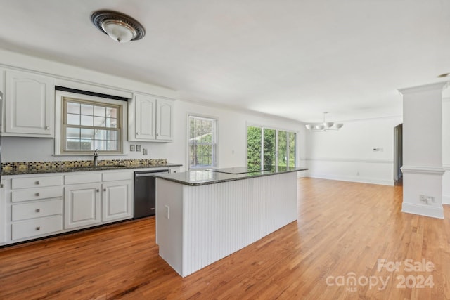 kitchen with light hardwood / wood-style flooring, a kitchen island, stainless steel dishwasher, and white cabinetry