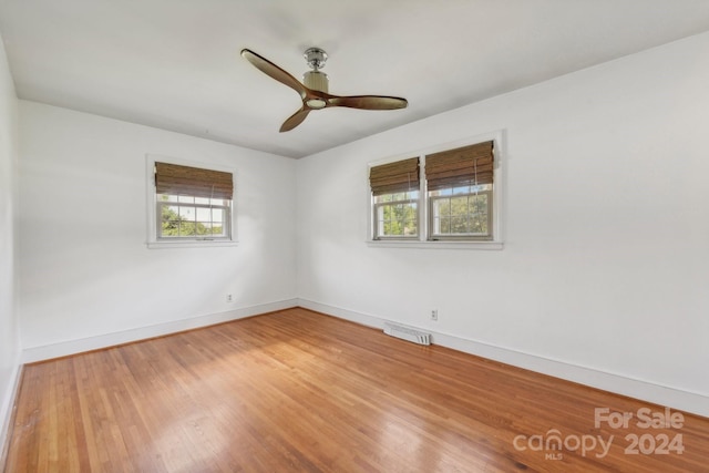 empty room with ceiling fan and hardwood / wood-style flooring