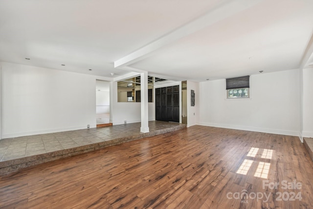 unfurnished living room featuring wood-type flooring and elevator