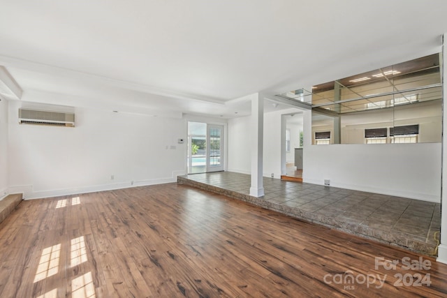 empty room featuring hardwood / wood-style floors and a wall mounted air conditioner