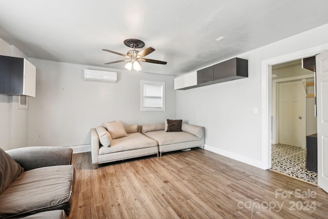 living room with an AC wall unit, light hardwood / wood-style floors, and ceiling fan