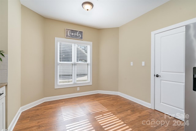 unfurnished room with hardwood / wood-style floors