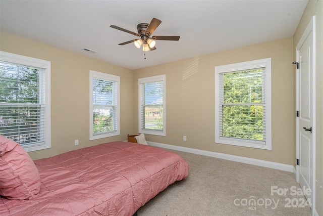 bedroom featuring light colored carpet and ceiling fan