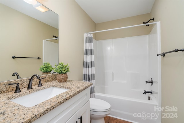 full bathroom with toilet, hardwood / wood-style flooring, shower / tub combo, and vanity