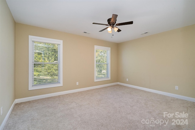 carpeted spare room with ceiling fan