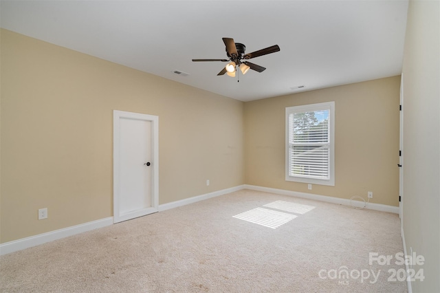 spare room featuring light carpet and ceiling fan