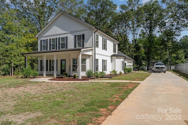 view of property featuring a front lawn and covered porch