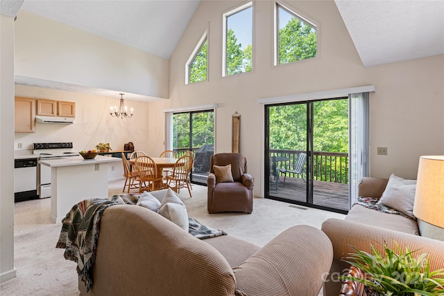 carpeted living room with high vaulted ceiling and an inviting chandelier