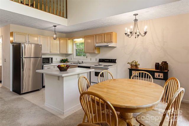 kitchen with stainless steel appliances, pendant lighting, light colored carpet, and light brown cabinets