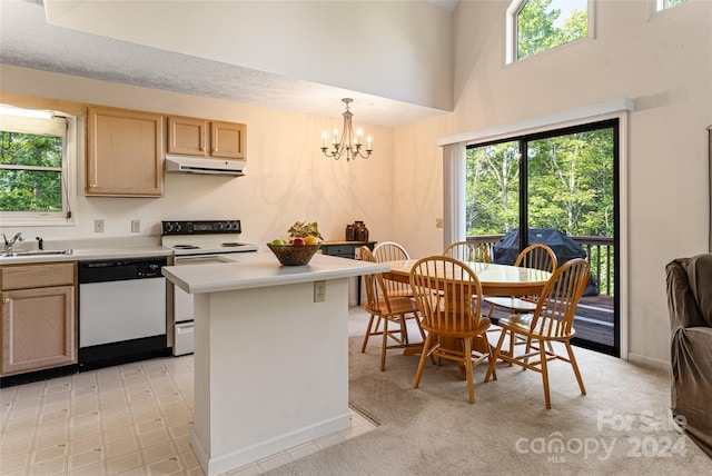 kitchen with a wealth of natural light, a towering ceiling, white appliances, and a chandelier