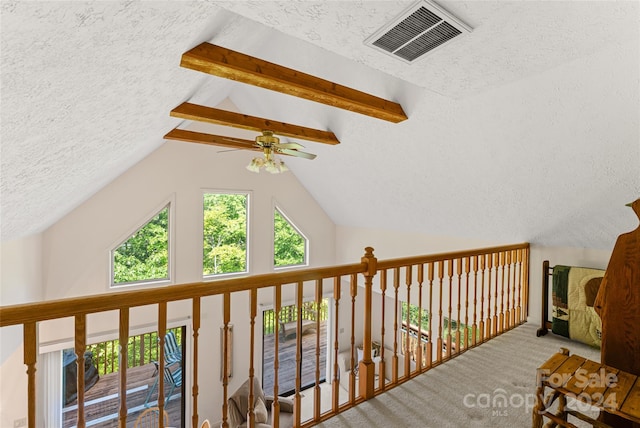 hallway with lofted ceiling with beams, carpet, and a textured ceiling