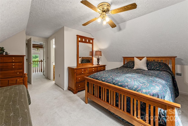 carpeted bedroom with ceiling fan, vaulted ceiling, and a textured ceiling