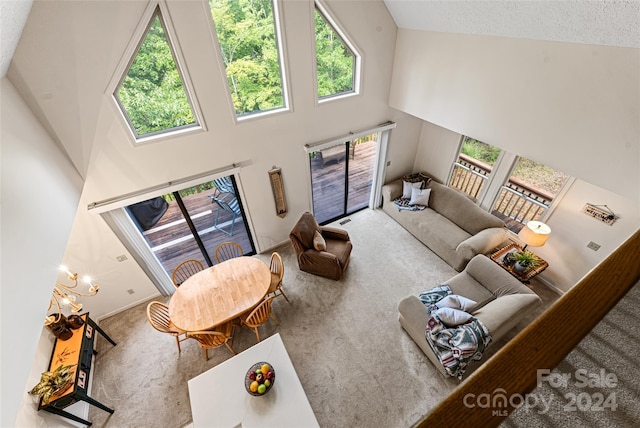 carpeted living room featuring a textured ceiling and high vaulted ceiling