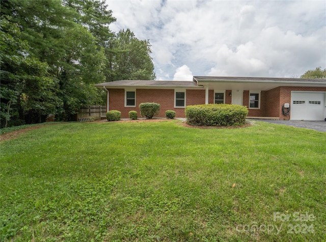 single story home featuring a garage, fence, a front lawn, and aphalt driveway