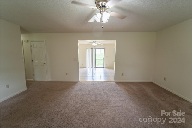 unfurnished room featuring a ceiling fan, baseboards, a textured ceiling, and light colored carpet