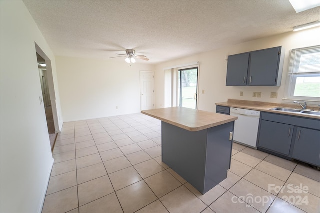 kitchen featuring a wealth of natural light, a center island, white dishwasher, and a sink