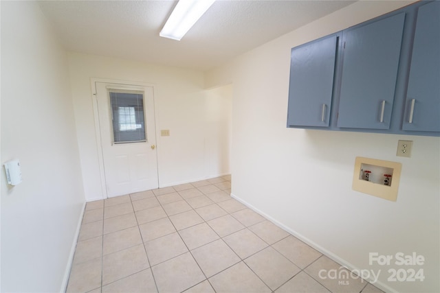 clothes washing area with cabinet space, hookup for a washing machine, baseboards, and light tile patterned flooring