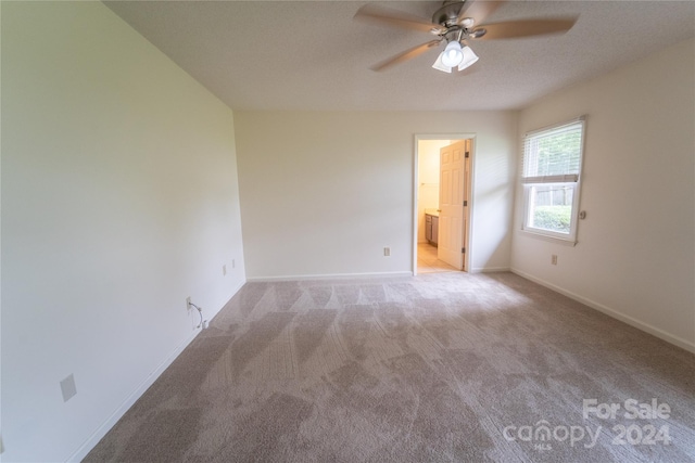 empty room featuring carpet, baseboards, and ceiling fan