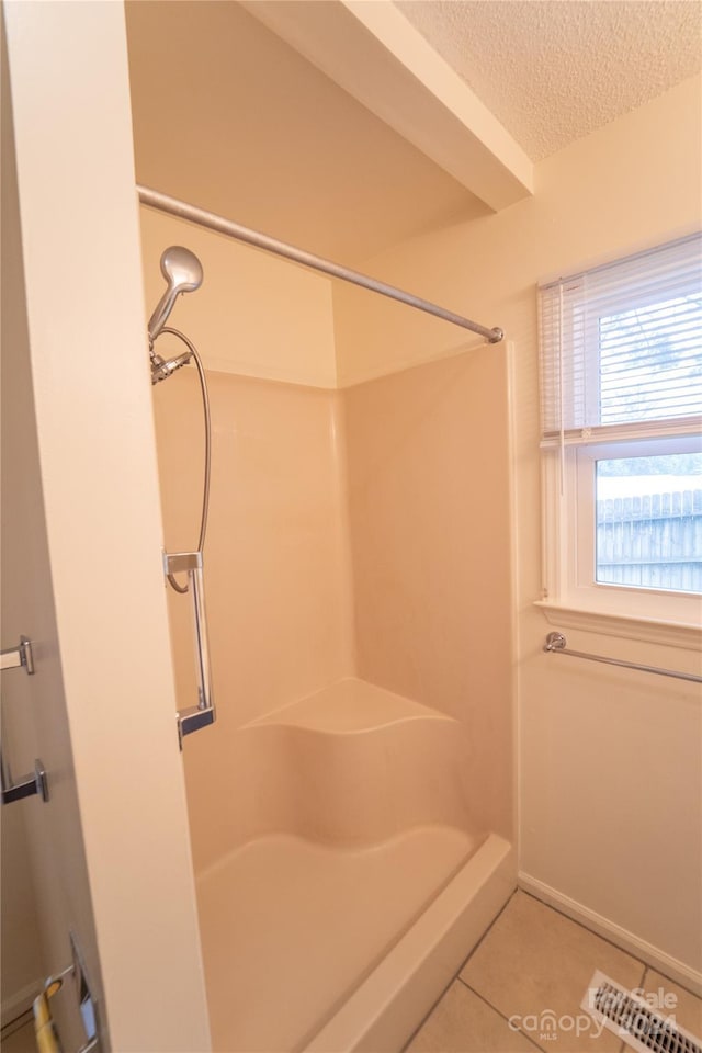 bathroom featuring tile patterned flooring, visible vents, walk in shower, and a textured ceiling