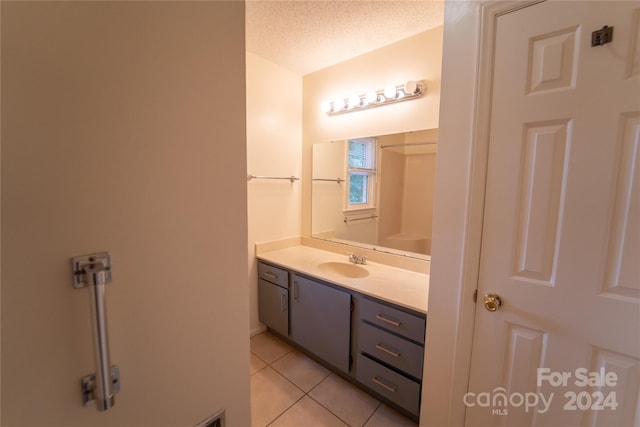 bathroom with a textured ceiling, vanity, and tile patterned floors