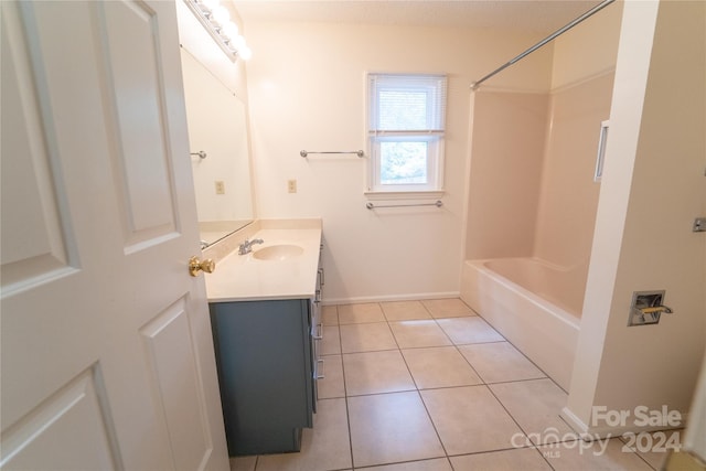 bathroom featuring vanity, baseboards, washtub / shower combination, and tile patterned floors