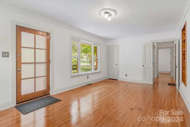 interior space with ornamental molding, baseboards, and light wood finished floors