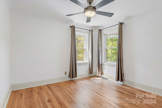 unfurnished room with baseboards, visible vents, light wood-style flooring, and crown molding