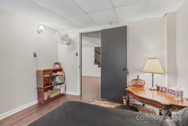 interior space featuring a paneled ceiling, stairway, baseboards, and wood finished floors