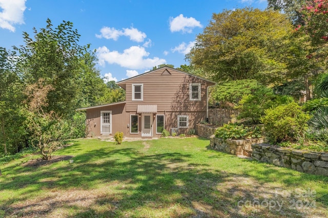 rear view of property with a lawn