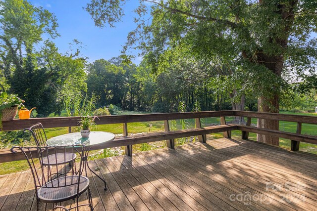 wooden terrace with a lawn