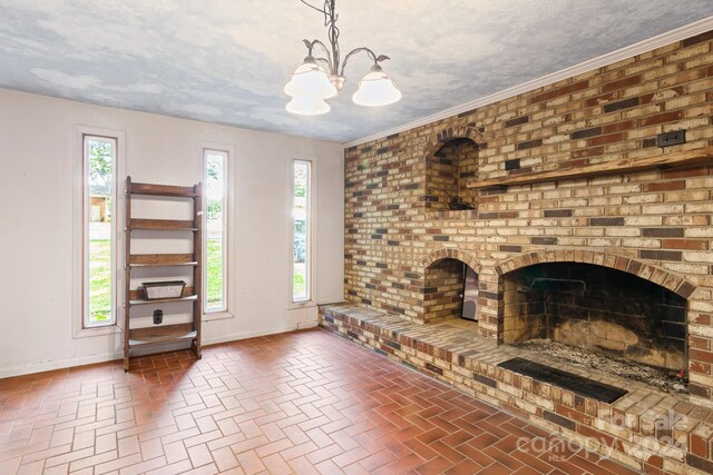 unfurnished living room with plenty of natural light, a textured ceiling, and a brick fireplace