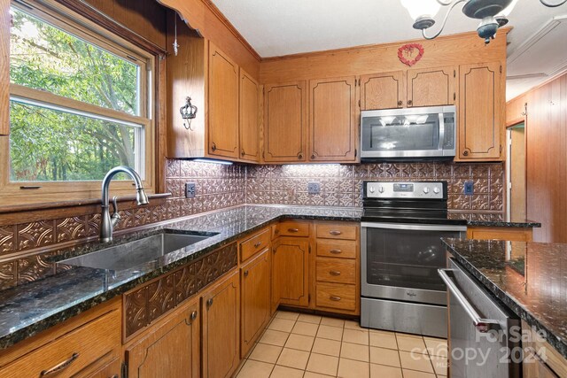 kitchen with dark stone countertops, appliances with stainless steel finishes, and decorative backsplash