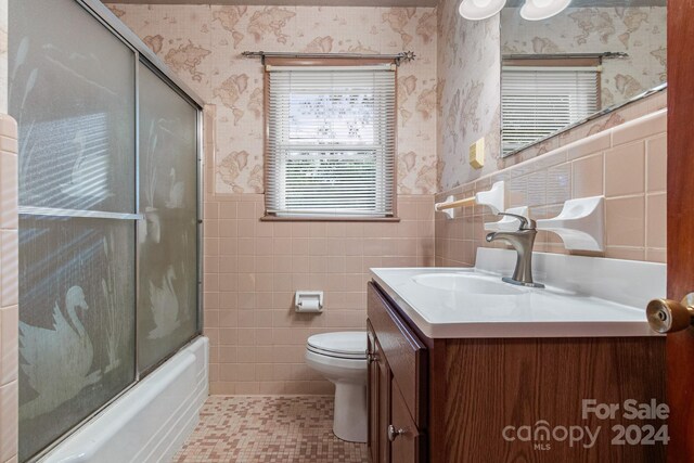 full bathroom featuring tile patterned flooring, toilet, tile walls, tasteful backsplash, and vanity