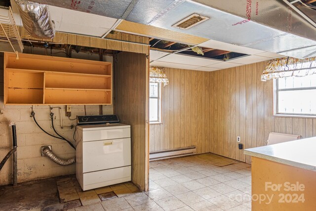 kitchen with washer / dryer, a baseboard radiator, and wood walls