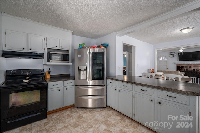 kitchen featuring under cabinet range hood, a peninsula, white cabinets, appliances with stainless steel finishes, and dark countertops