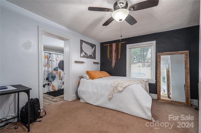 carpeted bedroom featuring ceiling fan and a textured ceiling