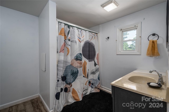 bathroom featuring visible vents, vanity, wood finished floors, a shower with curtain, and baseboards