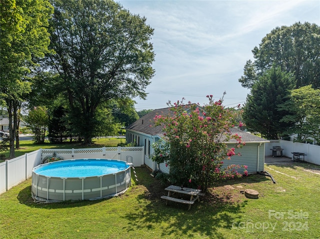 view of swimming pool featuring a yard, a fenced backyard, and a fenced in pool