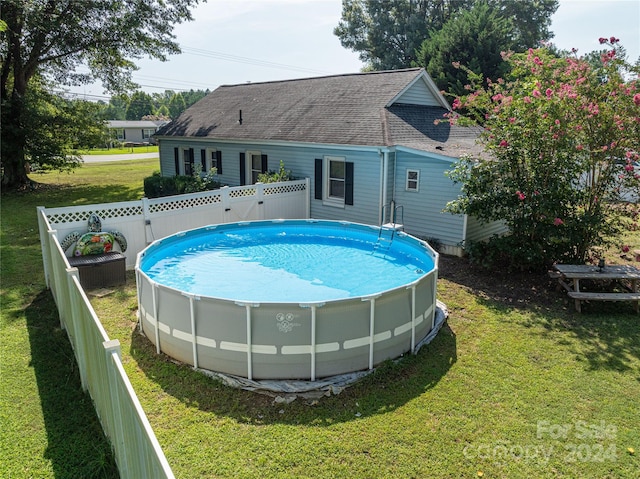 view of pool featuring a lawn, a fenced backyard, and a fenced in pool