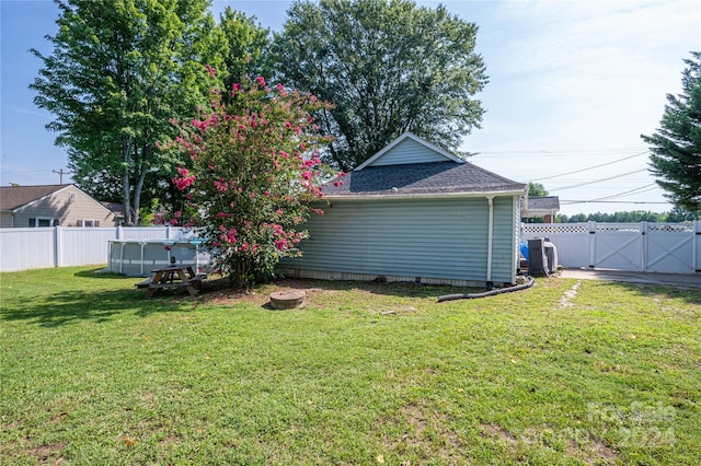 view of yard featuring a fenced backyard, a gate, and a fenced in pool