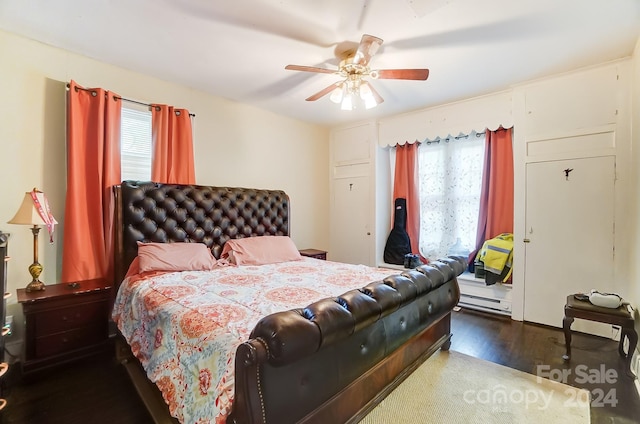 bedroom with ceiling fan, dark wood-type flooring, and multiple windows