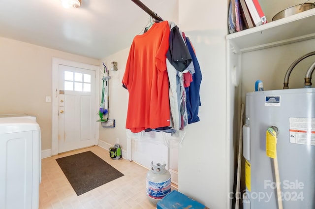 interior space with washer / dryer, electric water heater, and light tile patterned floors