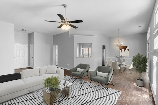 living room featuring ceiling fan with notable chandelier and hardwood / wood-style flooring