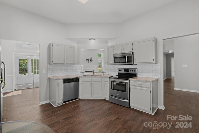 kitchen with dark hardwood / wood-style floors, sink, stainless steel appliances, and white cabinets