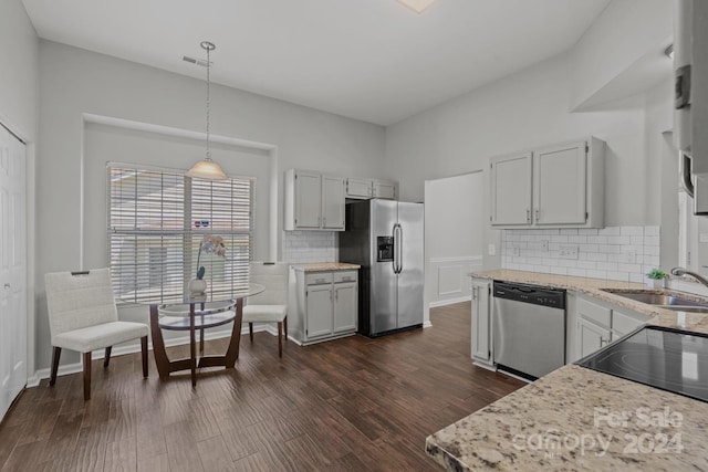 kitchen with sink, decorative light fixtures, appliances with stainless steel finishes, decorative backsplash, and dark hardwood / wood-style floors