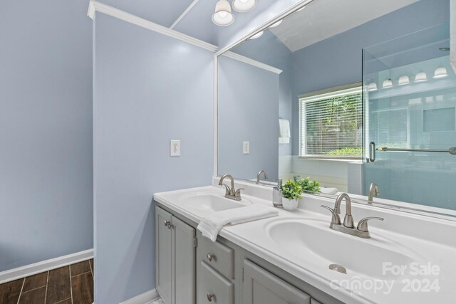 bathroom featuring tile patterned flooring, dual bowl vanity, and a shower with shower door