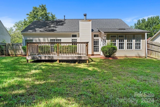 rear view of house with a wooden deck and a yard